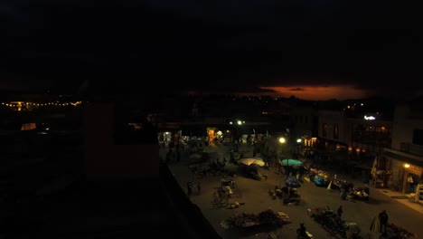 thunderstorm over the market in marrakech with a great orange sunset and lightnings in the far distance.