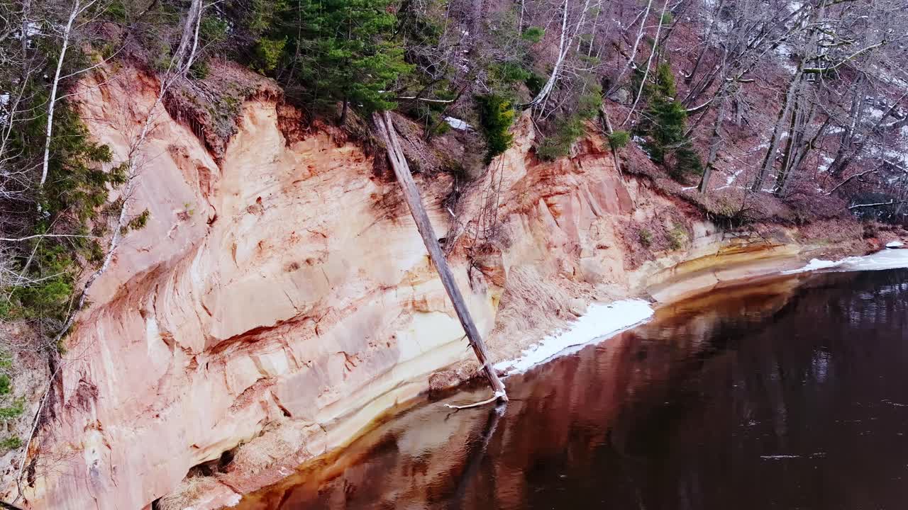 Close-up of striking sandstone formations, fallen tree reflecting in dark waters
