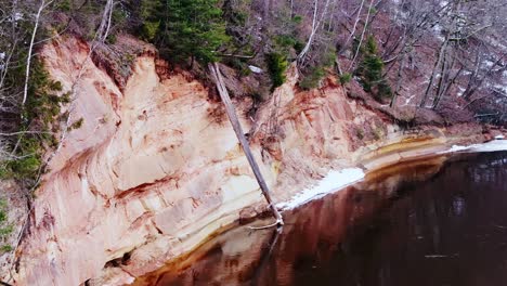 Close-up of striking sandstone formations, fallen tree reflecting in dark waters