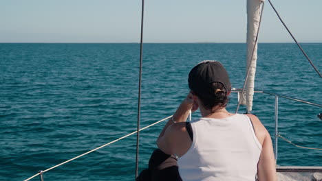 mujer sentada en la proa del velero disfrutando de navegar a través del océano pacífico sur