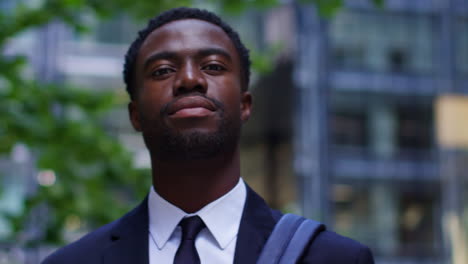 Portrait-Of-Confident-Young-Businessman-Wearing-Suit-Standing-Outside-Offices-In-The-Financial-District-Of-The-City-Of-London-UK-1