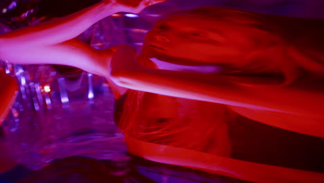 expressive female dancer performing movements in front of distorting mirror