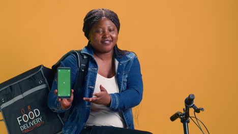 Female-Holds-Device-With-Green-Screen