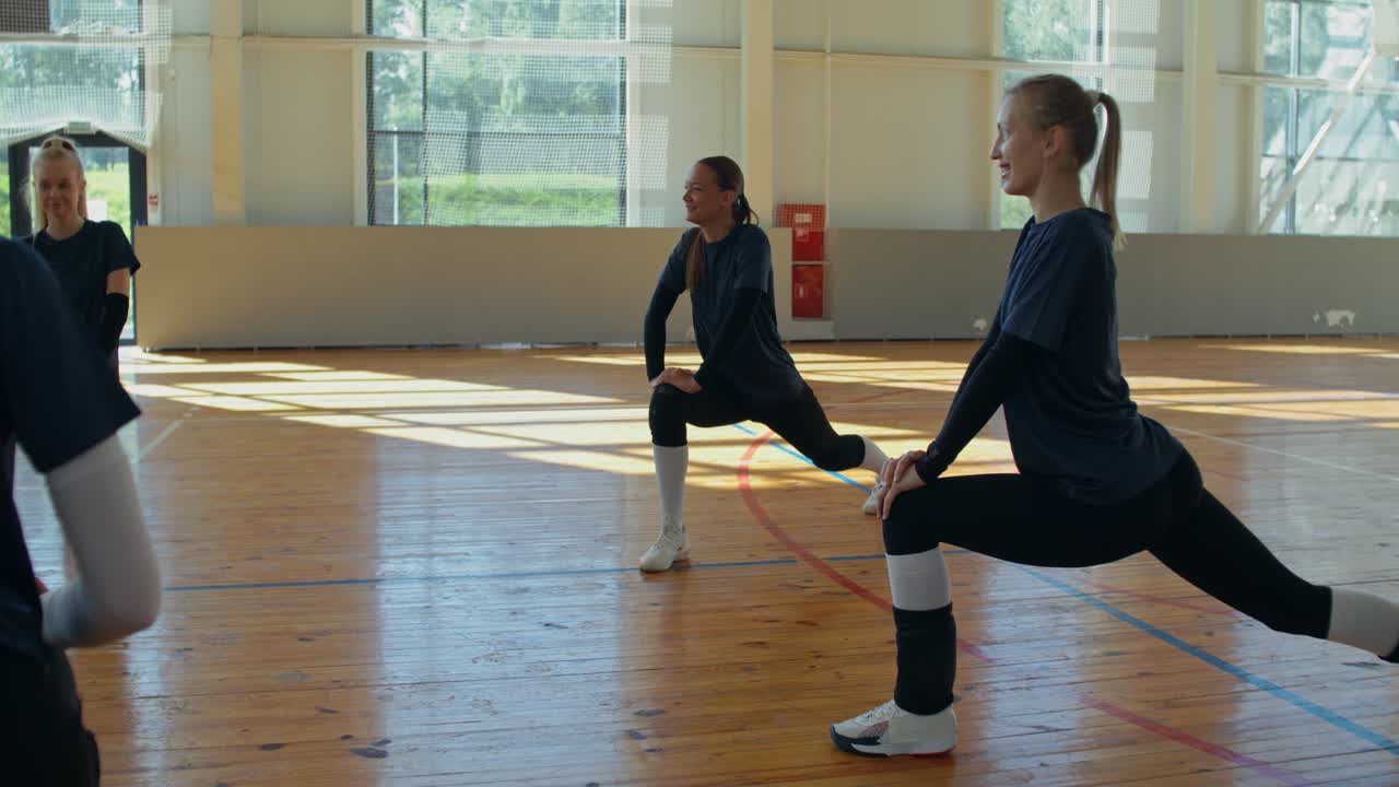Volleyball team stretching indoors