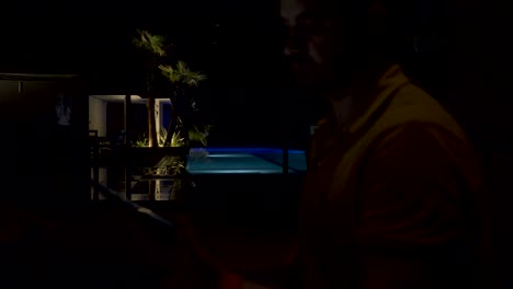 slow dolly shot of pool lights being turned off controlled by a tablet