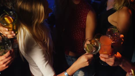 friends toasting cocktail glasses