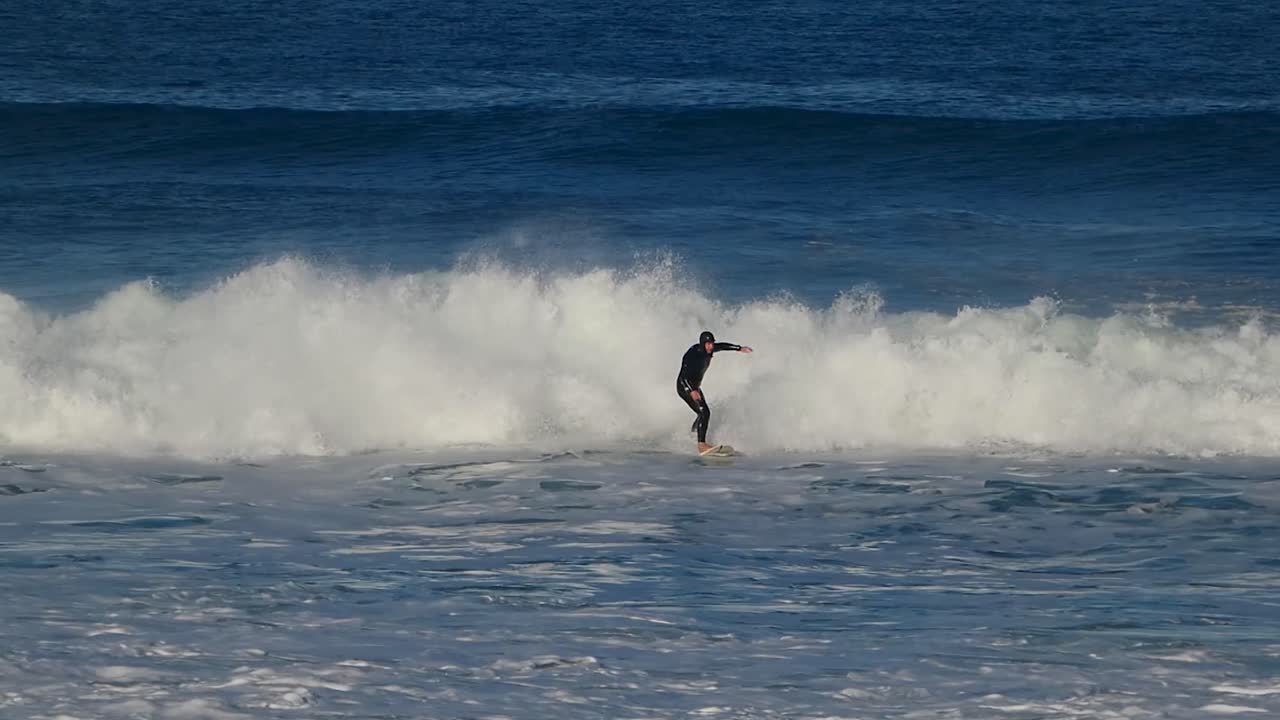 포르투갈 골드 코스트의 긴초 서프 스팟에서 카빙 탑 턴을 하는 슬로우 모션 샷 서퍼