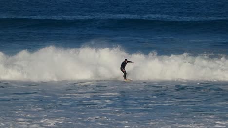 slow motion shot surfer of a performing a carving top turn at guincho surf spot on the gold coast of portugal