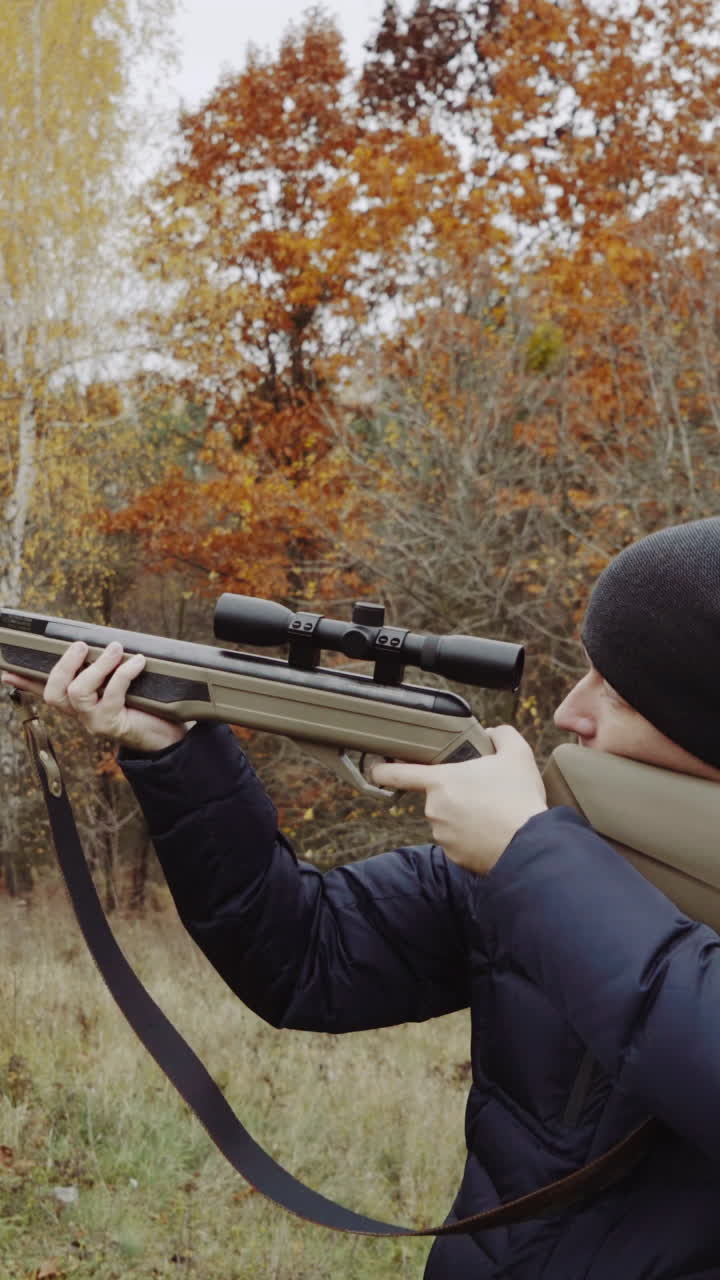 Hunter aiming for wildlife. Close up of hunter aiming down his rifle in autumn season