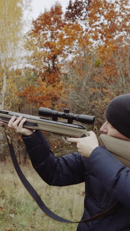 Hunter aiming for wildlife. Close up of hunter aiming down his rifle in autumn season