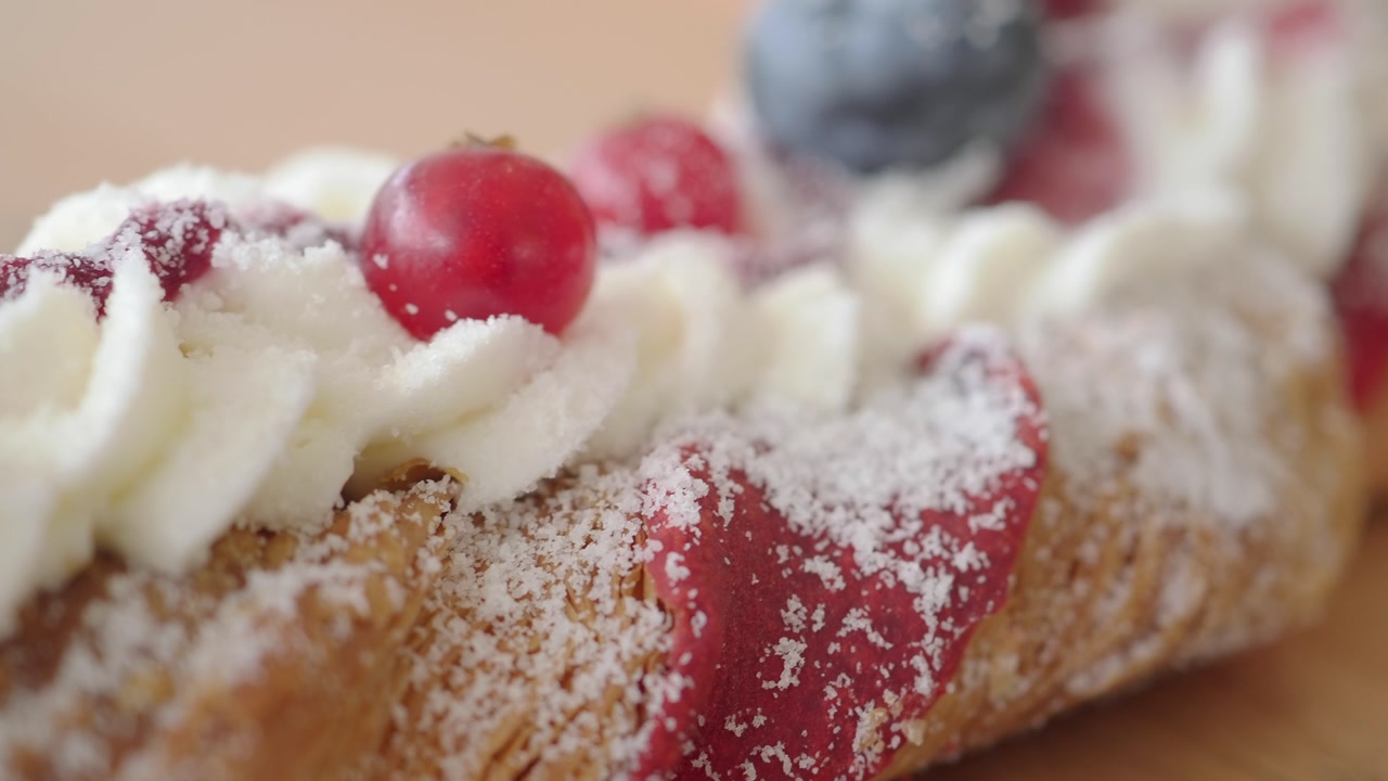 Close-up of a Gourmet Berry Pastry with Whipped Cream and Powdered Sugar