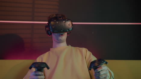 Aufgeregter-Junge,-Der-Videospiele-Spielt,-Eine-Virtual-Reality-Brille-Trägt-Und-Gamepads-Verwendet,-Die-Zu-Hause-Auf-Dem-Sofa-Sitzen-1