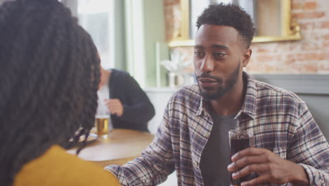 Smiling-Young-Couple-On-Date-Enjoying-Pizza-In-Restaurant-Together-Making-A-Toast