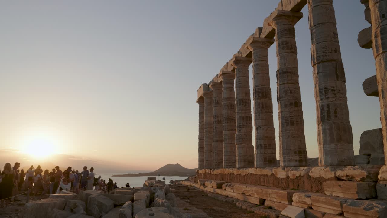 Tilt down reveal over Temple of Athena Sounias at sunset