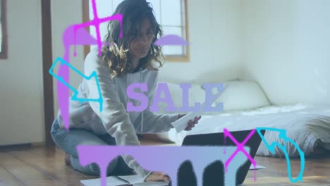 animation of sale text banner against caucasian woman calculating finance using laptop at home