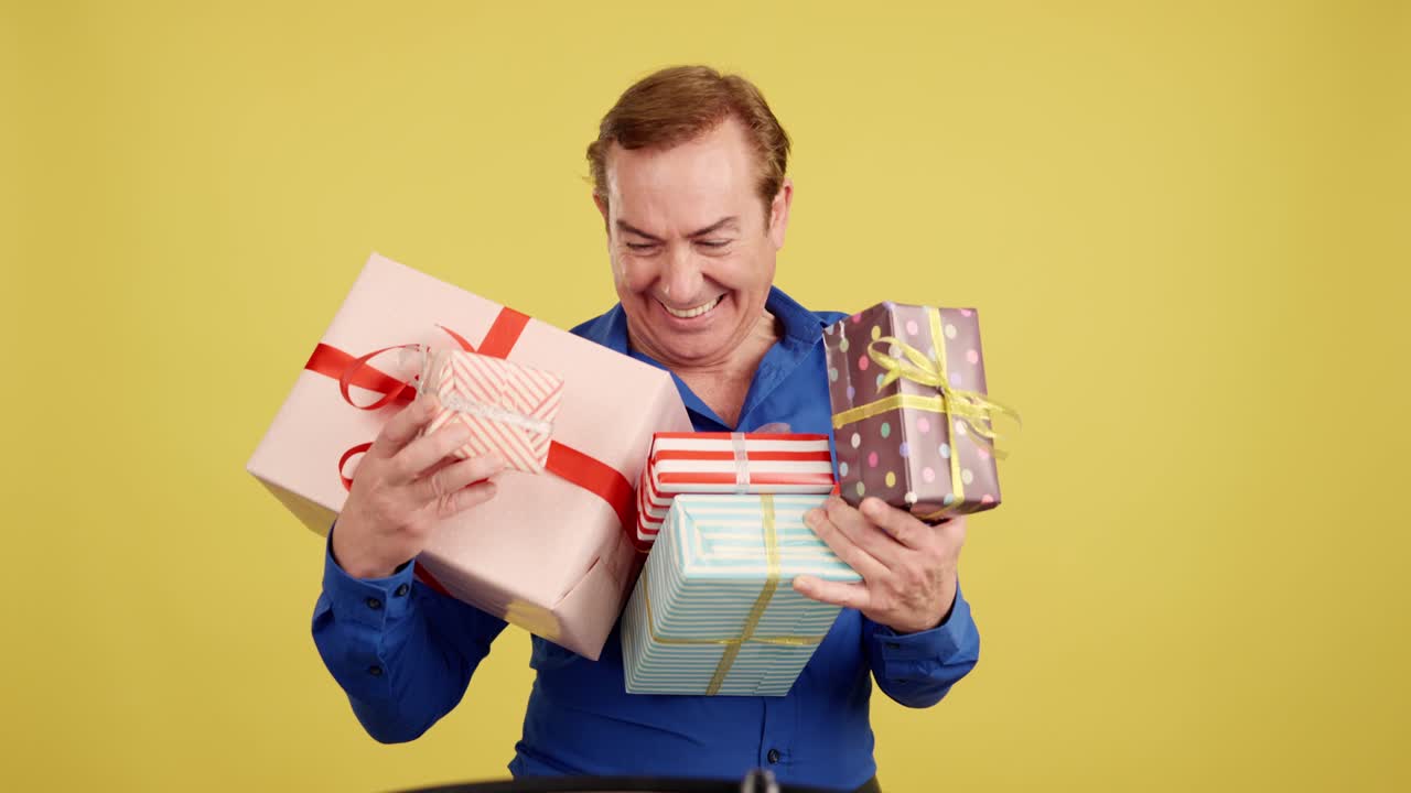 Man holding a pile of gifts with various expressions