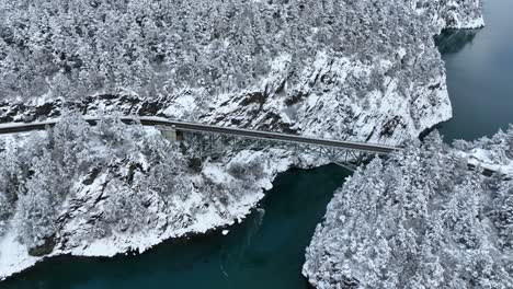 Vista-Aérea-Alta-De-Un-Puente-En-El-Estado-De-Washington-Cubierto-De-Nieve