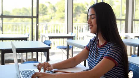 estudiante que usa tableta digital y computadora portátil en el aula