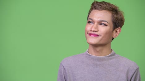 happy young androgynous asian man thinking