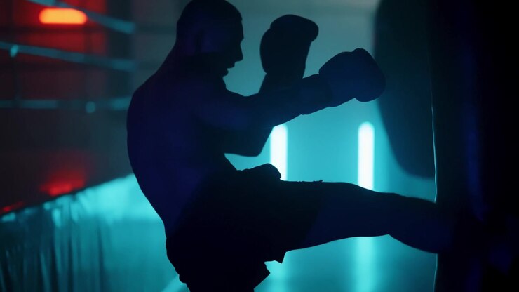 Sagoma di pugile che si allena con il sacco da boxe in una palestra illuminata al neon
