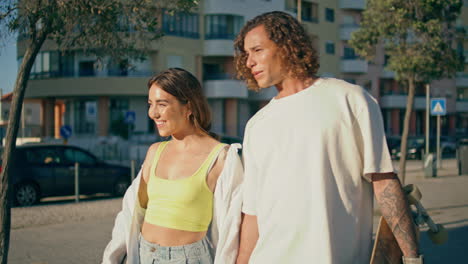 couple skateboarding in city street