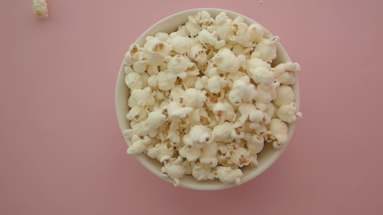 Ciotola di popcorn su sfondo rosa