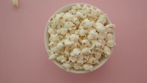 bowl of popcorn on a pink background