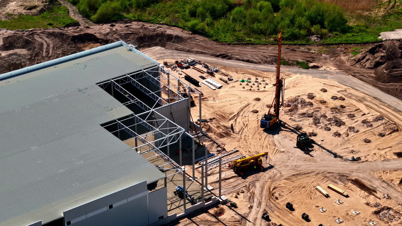 Latvian flag waving in wind near transit station, top-down view with cars and tracks