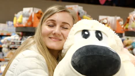 receiving a large soft toy dog as a gift receiving a large soft toy dog as a birtay present happy blonde girl