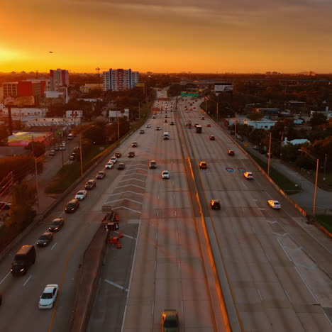 flying above the multi-lane road at sunset. orange light of setting sun covering the scenery of miami, florida, usa.
