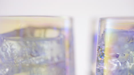 Schillernde-Gläser,-Die-Sich-Mit-Sprudelndem-Eiskaltem-Sodawasser-Drehen