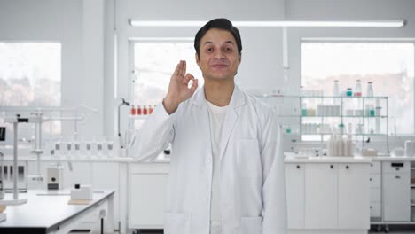 un científico indio feliz mostrando una señal de que está bien
