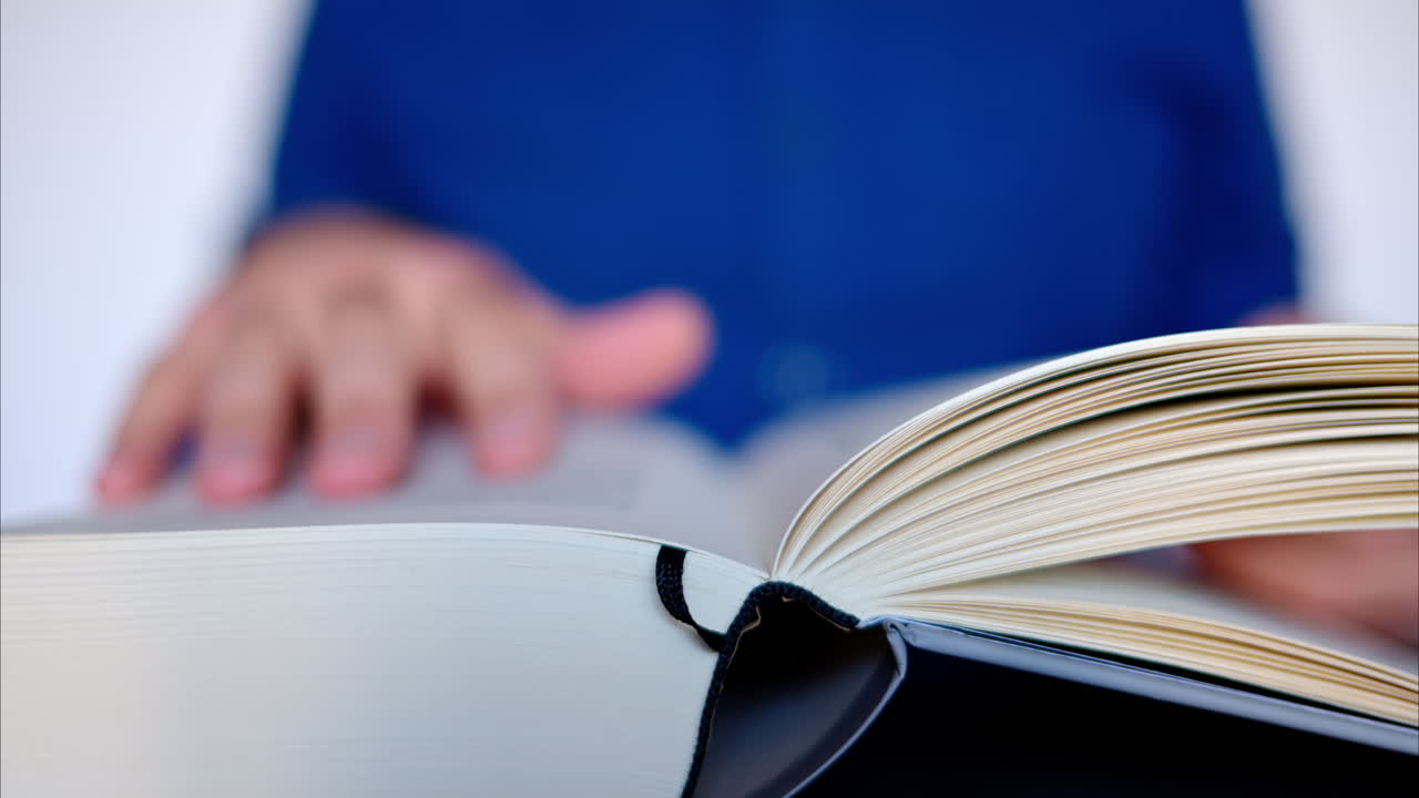 Primo piano di un uomo che consulta un grosso libro