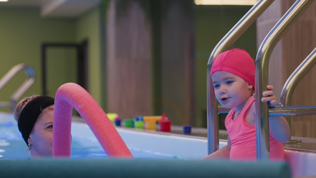 Toddler sits calmly at entrance of swimming pool resting hands on edge, enjoying soothing moment with water sparkle around body, capturing peaceful childhood leisure time with sense of relaxation
