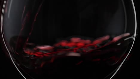 close up of red wine being poured into a glass