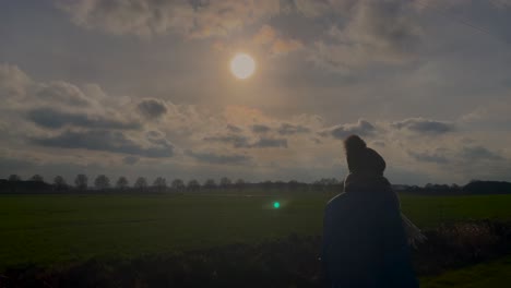 static slow motion shot of attractive girl with hat enjoying walk outside along agricultural field path