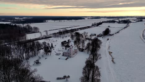 Stone-castle-standing-alone-in-a-vast,-snow-covered-field,-under-a-warm-evening-sky