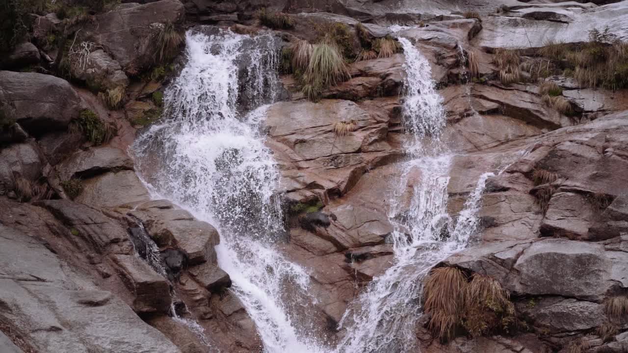 foque ancho medio hacia abajo toma en cámara lenta de la corriente de la cascada al estanque