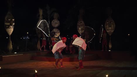 performers dancing during balinese african rhythm dance show at night bali safari and marine park, indonesia - slow motion