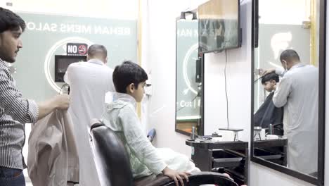 young boy getting haircut at barber shop