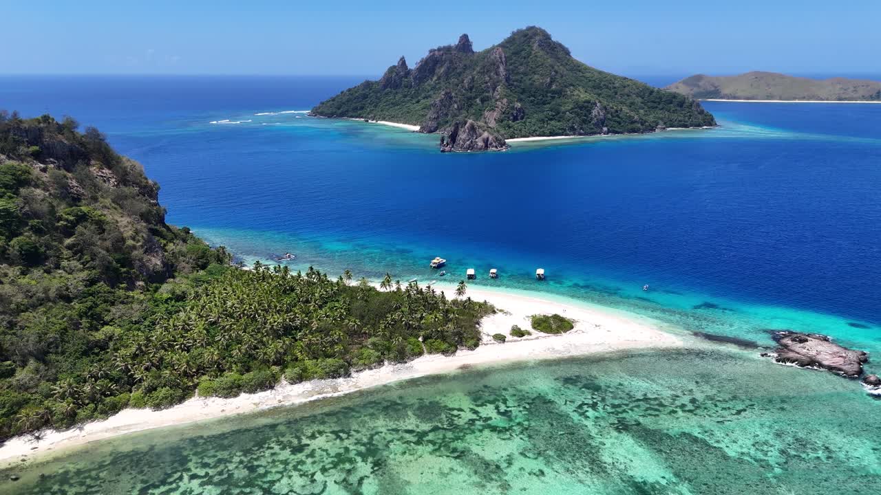 Stunning panoramic aerial drone view of Castaway Island, Fiji. A lush green tropical paradise is perfectly framed by vibrant coral reefs and the turquoise Pacific Ocean