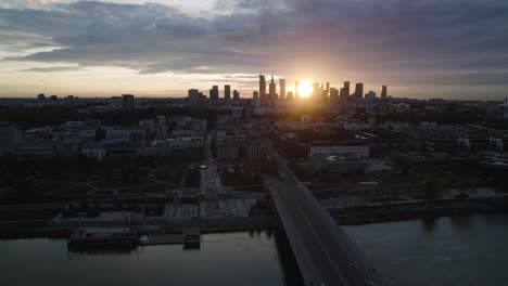 aerial cityscape of warsaw city by a bridge at vistula shore at sunset