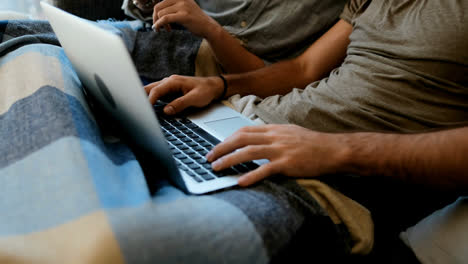 Couple-using-mobile-phone-and-laptop-in-living-room-4k