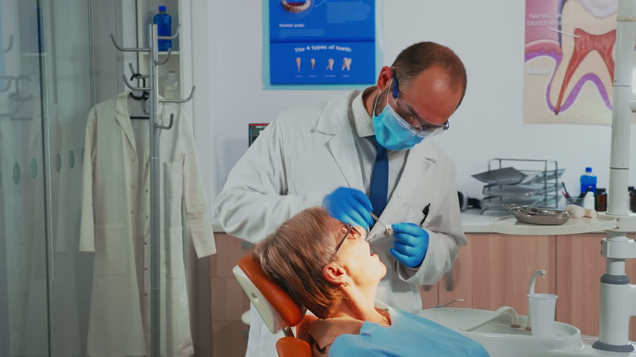 Ortodontista che esamina un paziente usando strumenti dentali sterili