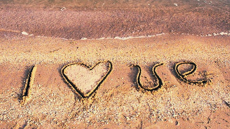 Inscriptie in zand. Ik hou van. Opname op het strand