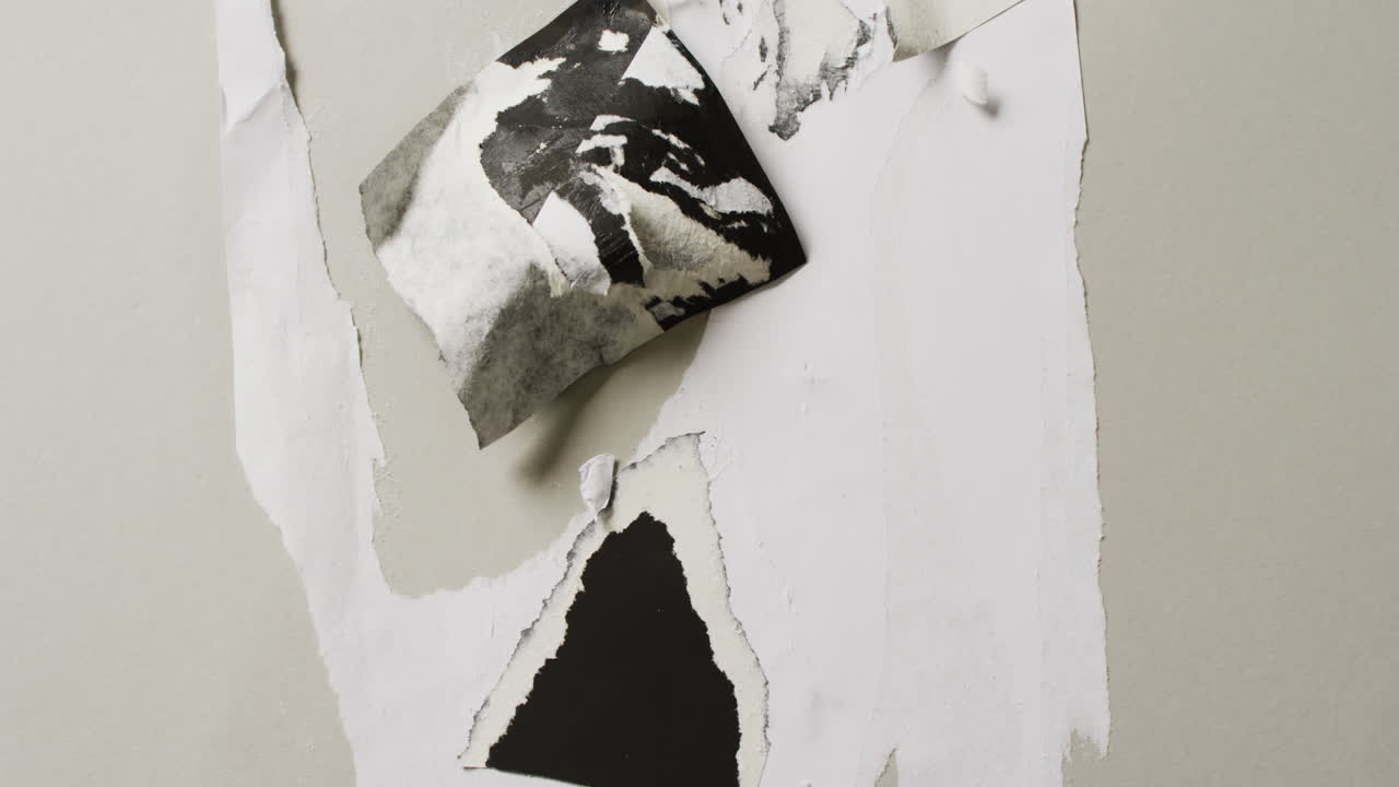 Video of close up of torn leyers of paper on white background