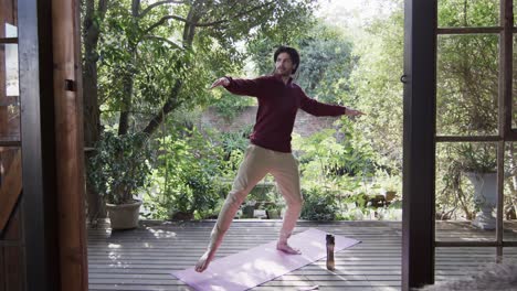 caucasian man practicing yoga on terrace in sunny nature, slow motion