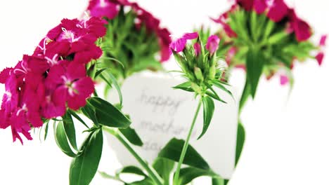 un ramo de rosas rosas con la etiqueta del día de las madres felices en un jarrón de flores