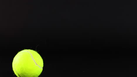a tennis ball rolls across a dark background