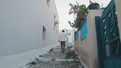 homme marchant dans une rue latérale grecque